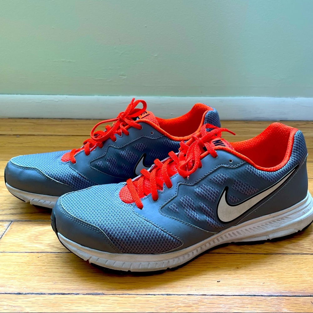 Nike Grey Downshifter 6 sneaker with orange accents.